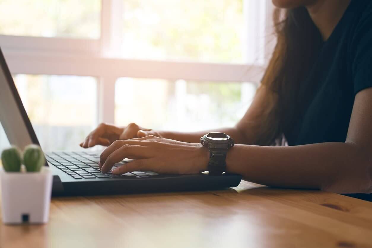 Young woman using working laptop computer on wood desk stock photo